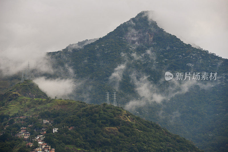 The Andaraí Maior peak above the Atlantic rainforest of Tijuca National Park and a favela